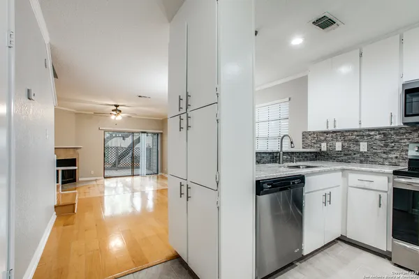 a kitchen with granite countertop a sink cabinets and stainless steel appliances