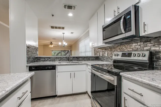a kitchen with stainless steel appliances granite countertop a stove and a microwave