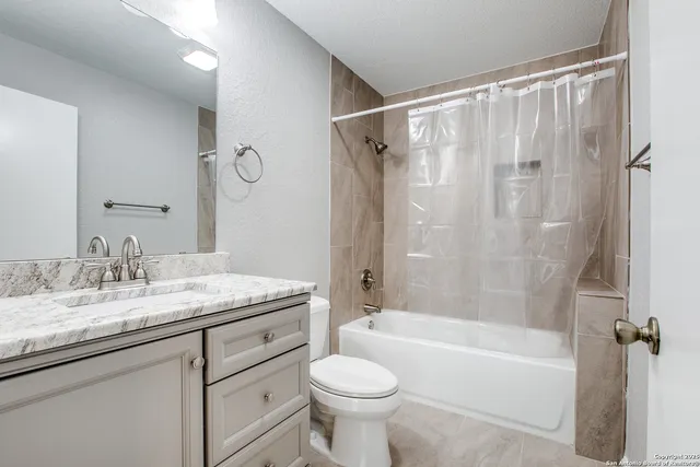 a bathroom with a granite countertop sink toilet and shower