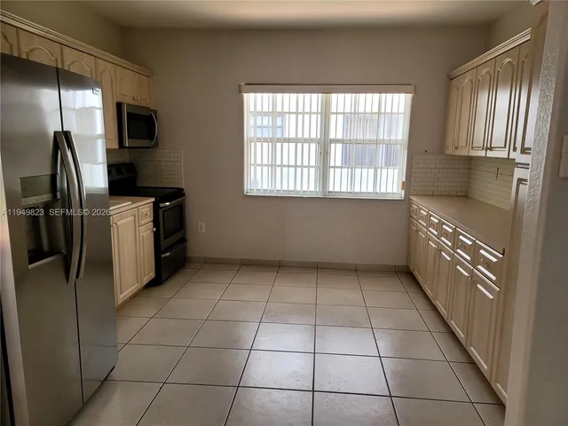 a kitchen with stainless steel appliances granite countertop a refrigerator and a stove