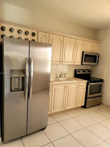 a kitchen with stainless steel appliances granite countertop a refrigerator and a stove