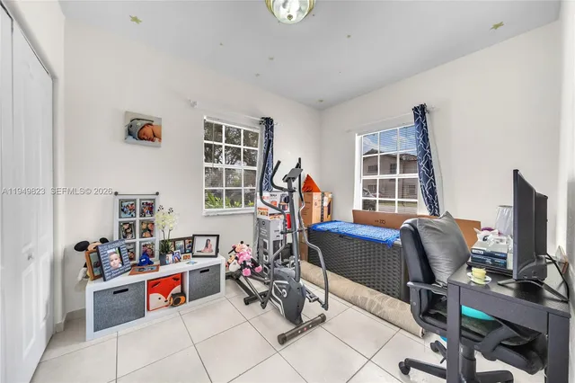 a view of a workspace with furniture and a window