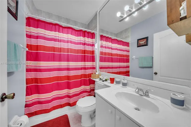 a bathroom with a sink a toilet and shower curtain