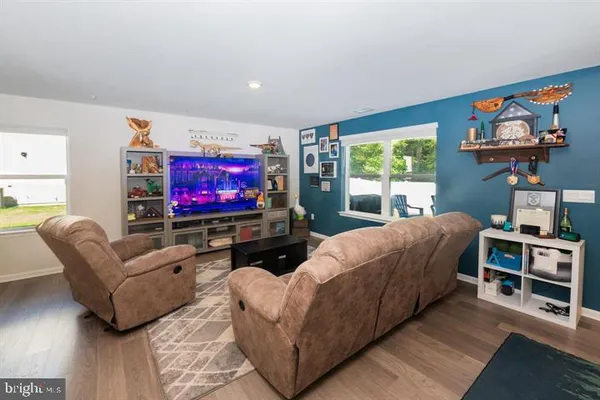 a living room with furniture a flat screen tv and a floor to ceiling window
