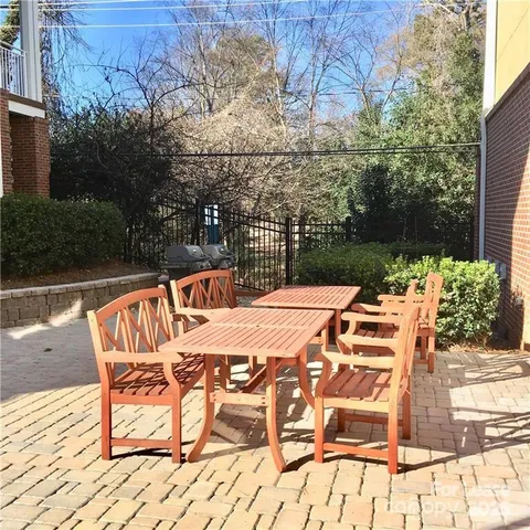 a view of a patio with table and chairs with wooden floor and fence
