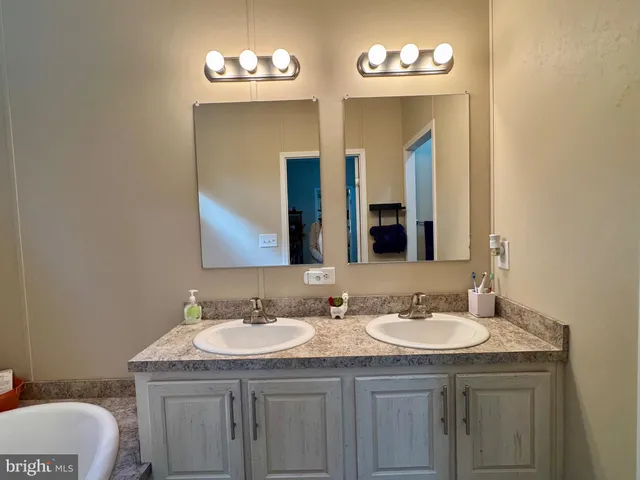 a bathroom with a granite countertop sink a mirror and a toilet
