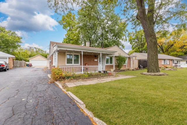 a view of a house with a backyard and a tree