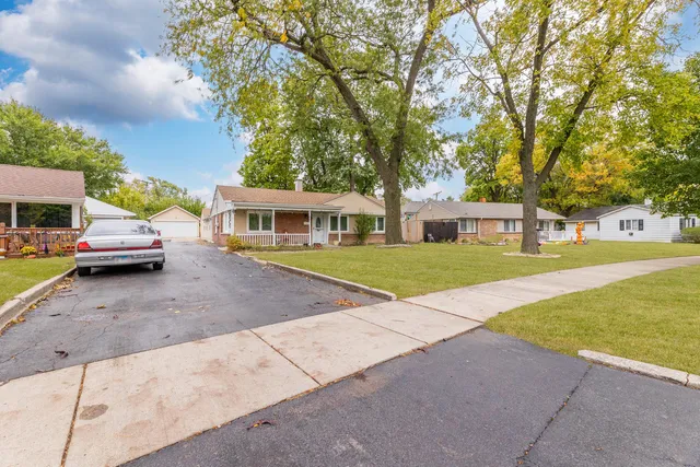 a view of house with yard and large trees