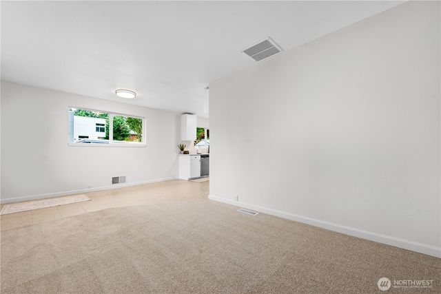 an empty room with windows and mirror