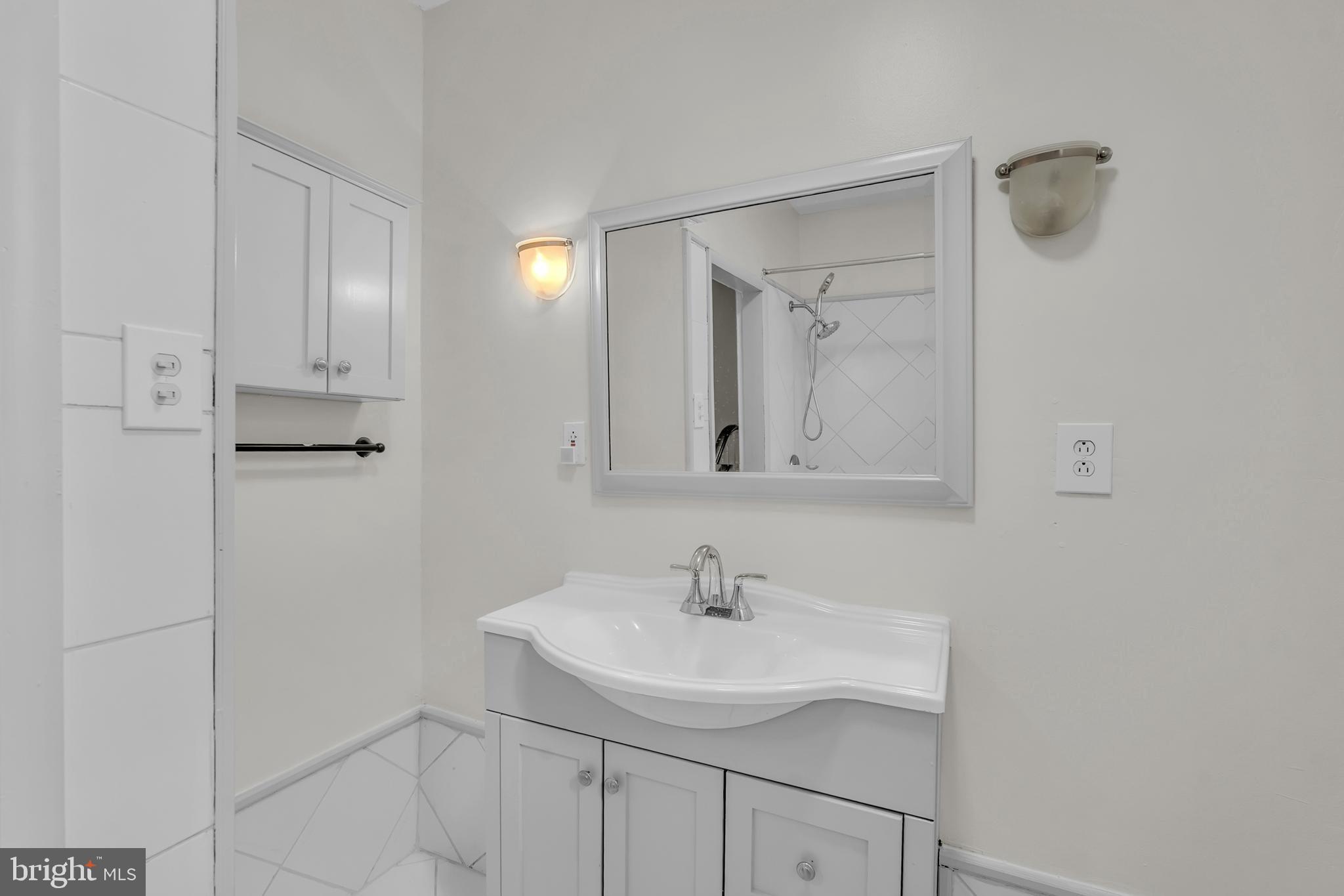 1419 Ellsworth Street Philadelphia, PA 19146 - Photo 11 of 17 a bathroom with a sink and a mirror