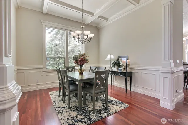 a view of a dining room with furniture a chandelier and wooden floor