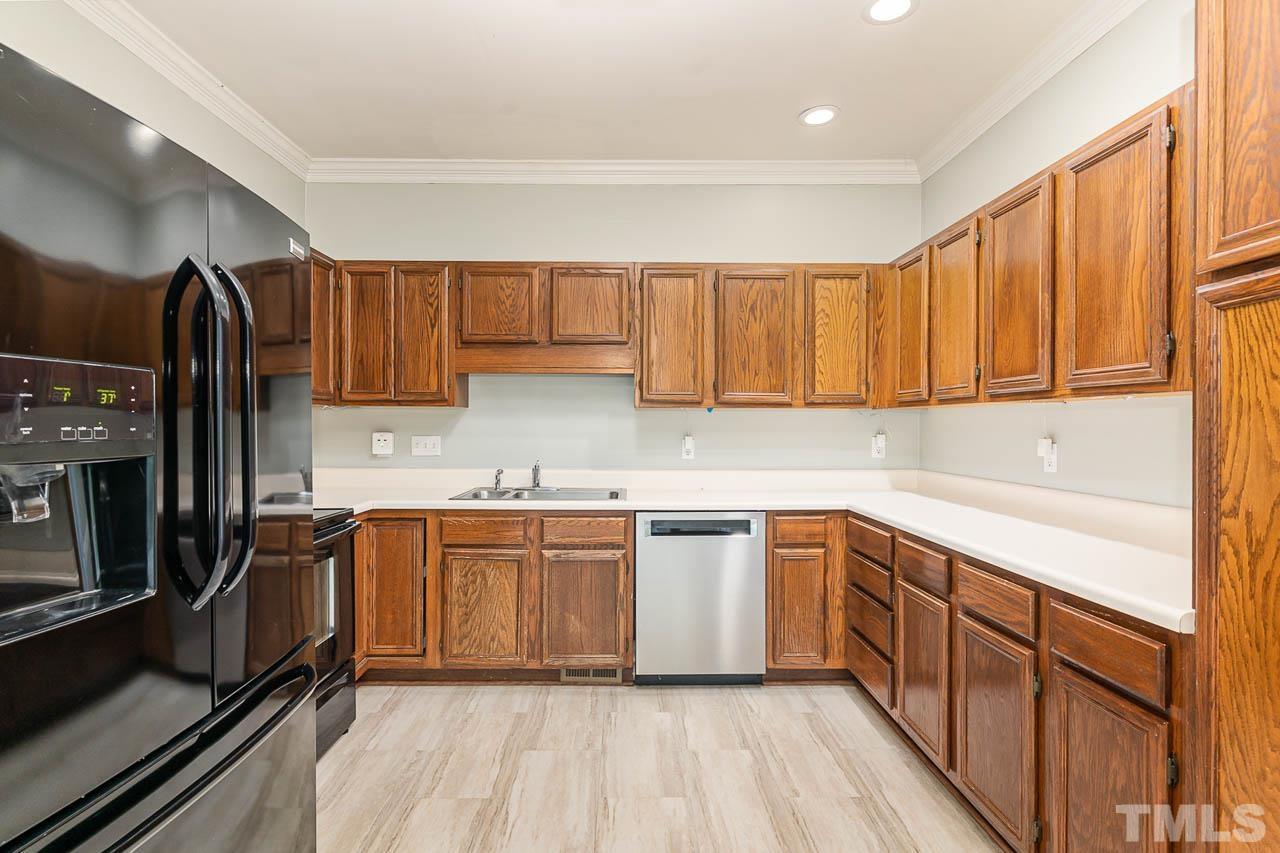 2909 Englefield Drive Raleigh, NC 27615 - Photo 19 of 31 a kitchen with stainless steel appliances granite countertop a stove a sink dishwasher and a refrigerator