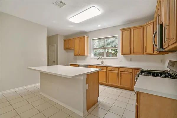 a kitchen with stainless steel appliances granite countertop a sink and a stove top oven with wooden floor