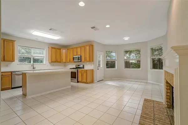 a large white kitchen with a stove a sink dishwasher and a refrigerator