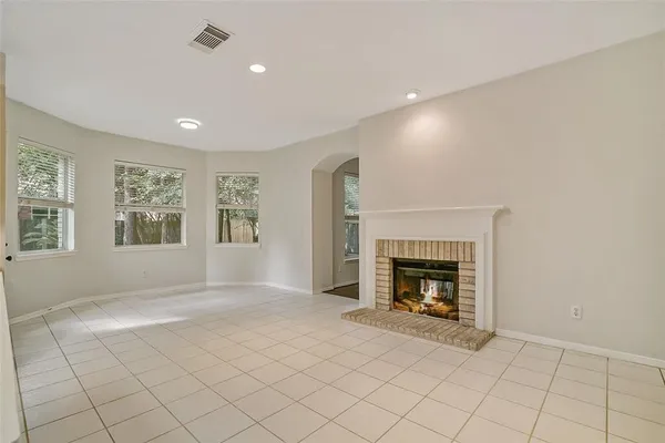 an empty room with windows and fireplace