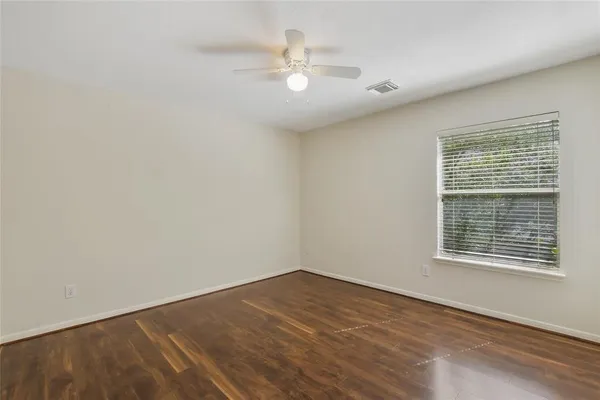 an empty room with a window and a fan