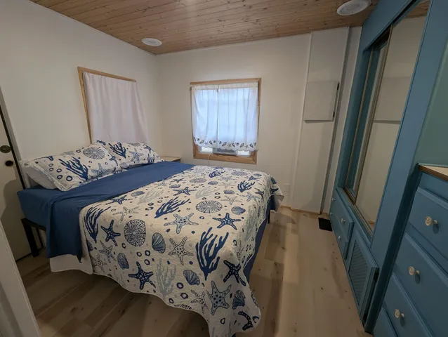 a bedroom with a bed and wooden floor