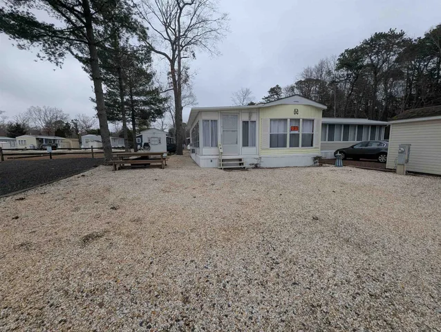 a view of a house with a yard covered in the forest