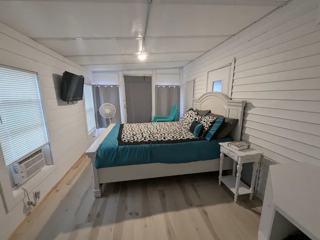 a bedroom with a bed window and a dresser