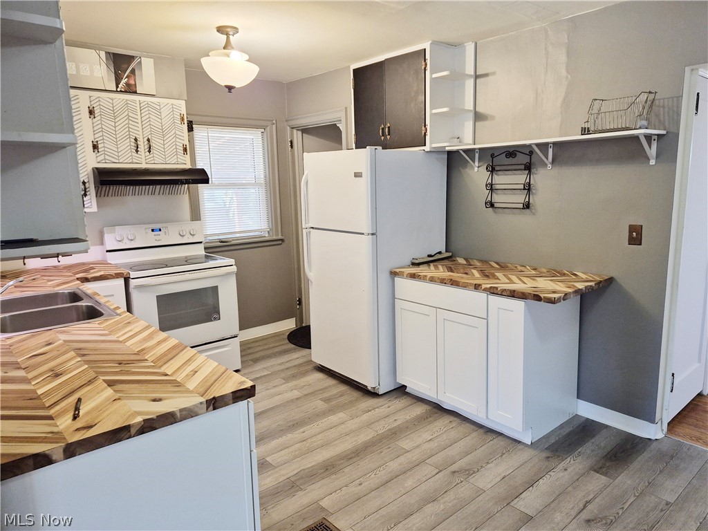 351 Niles Vienna Road Vienna, OH 44473 - Photo 8 of 30 Kitchen with open shelves, butcher block counters, white appliances, light wood-style flooring, and white cabinetry