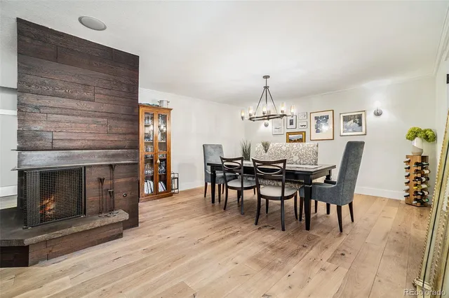 a dining room with wooden floor a chandelier a wooden table and chairs