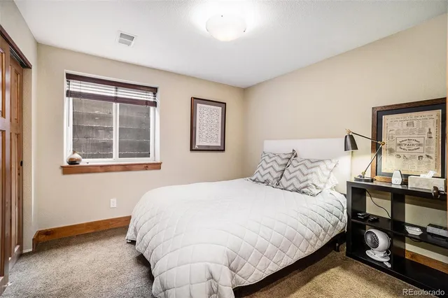 a bedroom with a bed and dresser with mirror