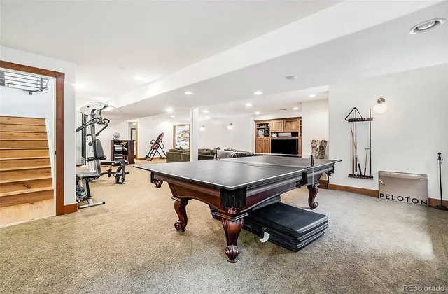 a room with furniture pool table and chairs