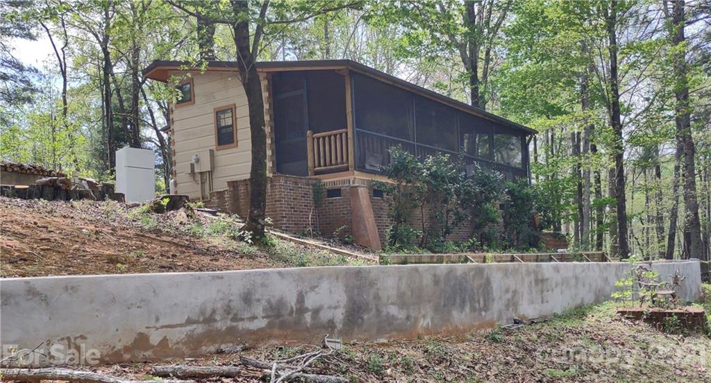120 Ridge Road Mill Spring, NC 28756 - Photo 1 of 1 a backyard of a house with large tree and wooden fence