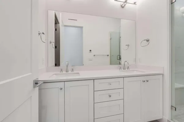 a bathroom with double sink and a mirror