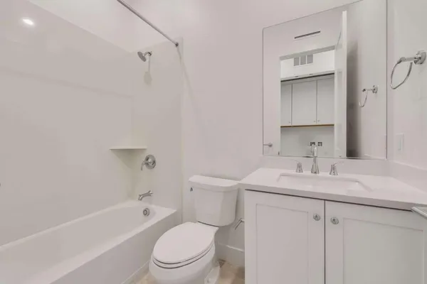 a bathroom with a sink toilet vanity tub and shower