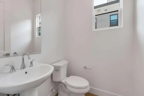 a bathroom with a sink mirror and toilet