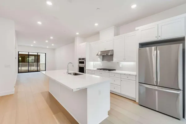 a kitchen with stainless steel appliances a refrigerator sink and cabinets