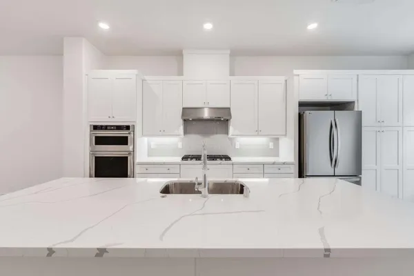 a kitchen with kitchen island a stove a refrigerator and a cabinets