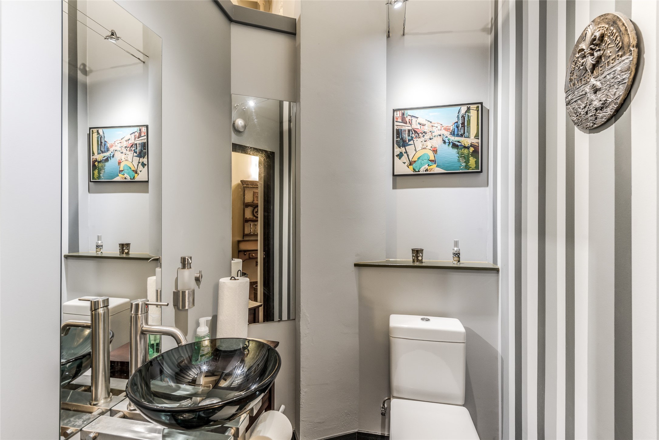 705 Main Street, Unit 215 Houston, TX 77002 - Photo 11 of 36 Half Bath features a sleek glass vessel sink, elegant fixtures, and stylish striped walls.