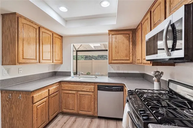 a kitchen with granite countertop white cabinets and black stainless steel appliances