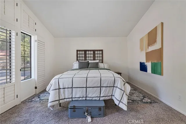 a bedroom with a bed and a painting on the wall
