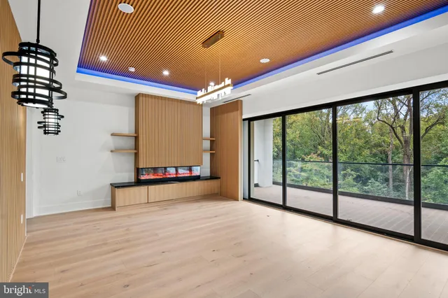 a view of an empty room with a window and chandelier