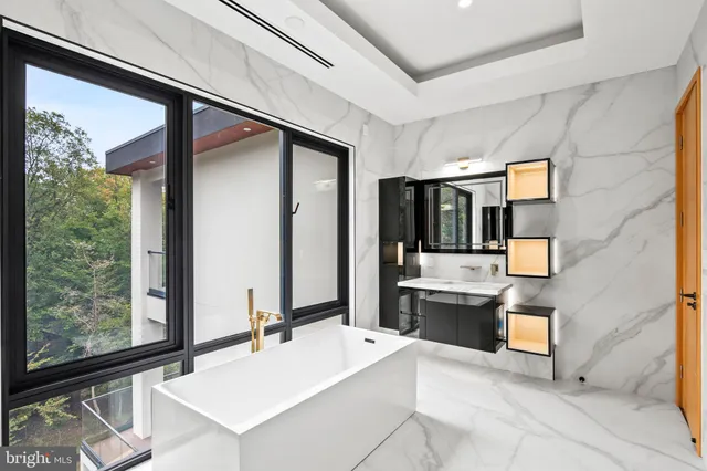 a view of a hallway with a large window and stainless steel appliances