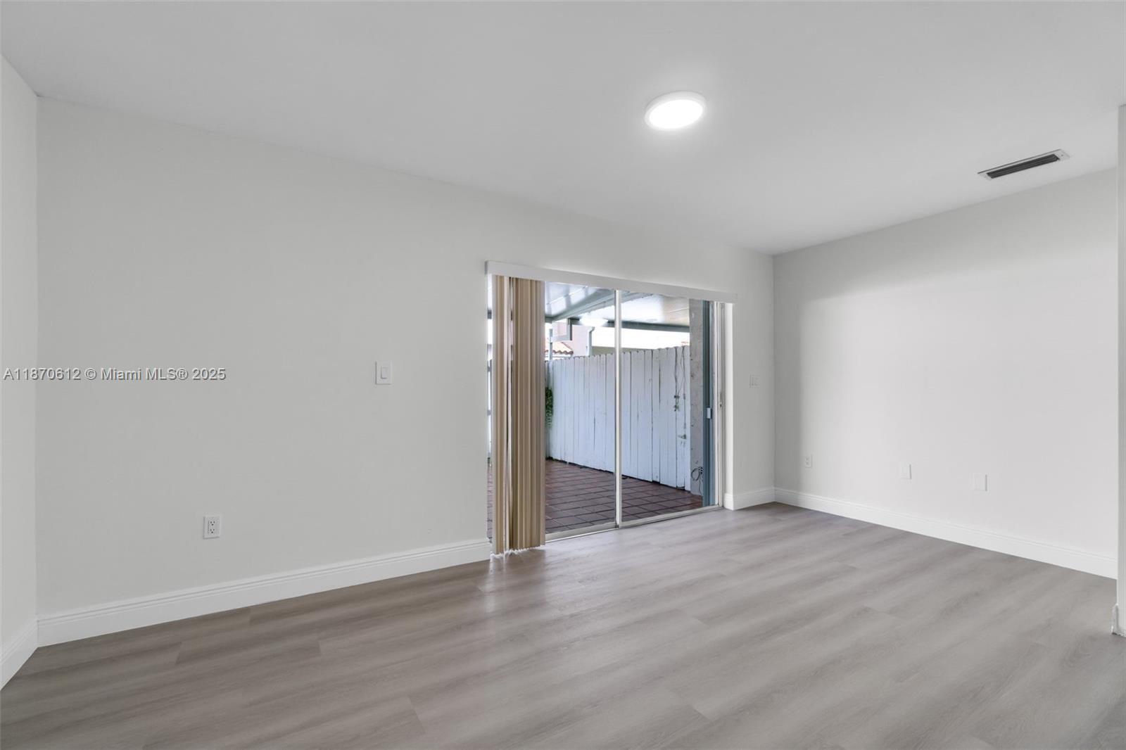 6514 Southwest 128th Place, Unit 6514 Miami, FL 33183 - Photo 13 of 46 an empty room with wooden floor and windows