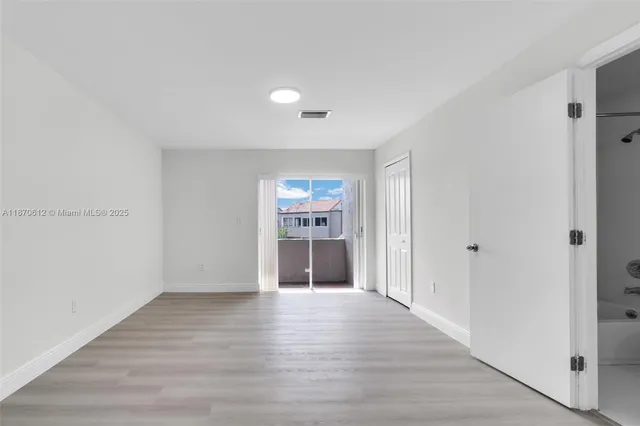 a view of an empty room with wooden floor