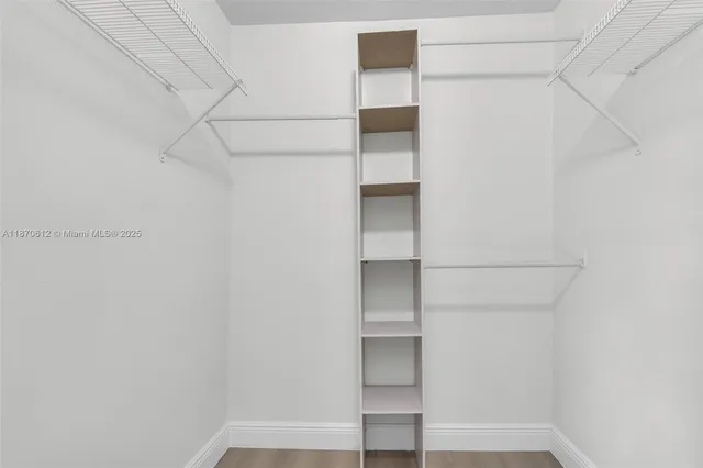 a view of walk in closet with empty racks