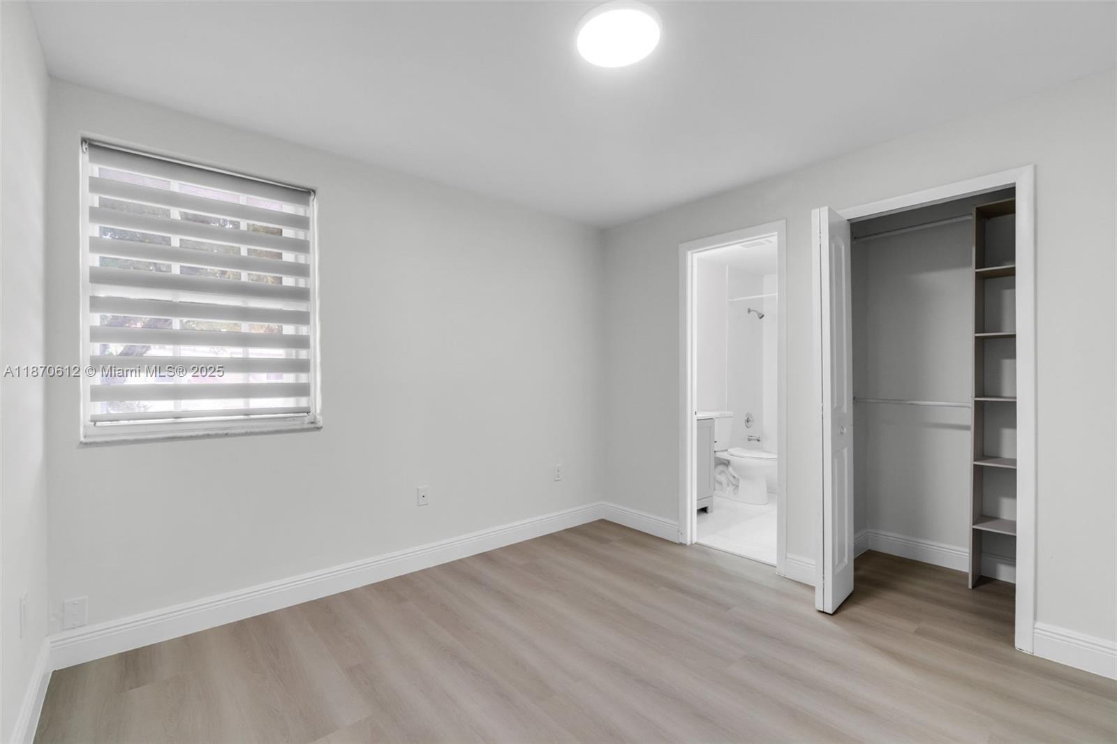 6514 Southwest 128th Place, Unit 6514 Miami, FL 33183 - Photo 22 of 46 a view of an empty room with wooden floor and a window