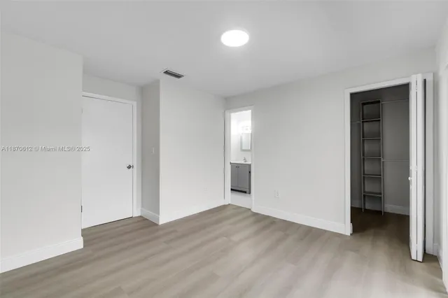 an empty room with wooden floor and closet