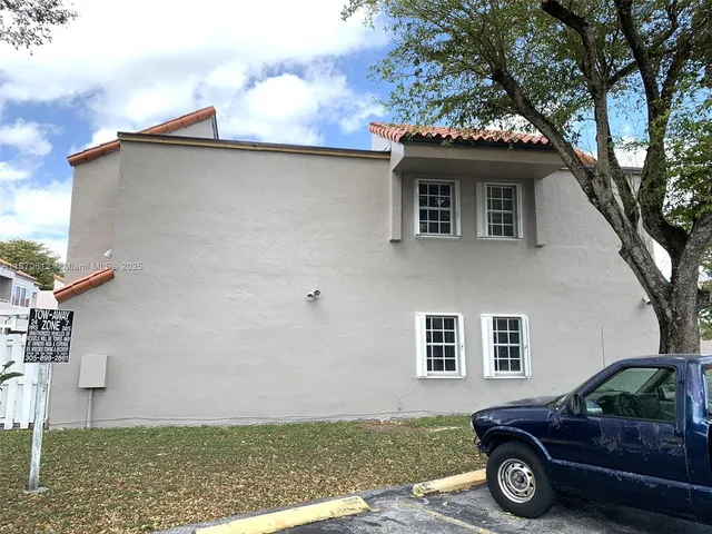 a car parked in front of a white house