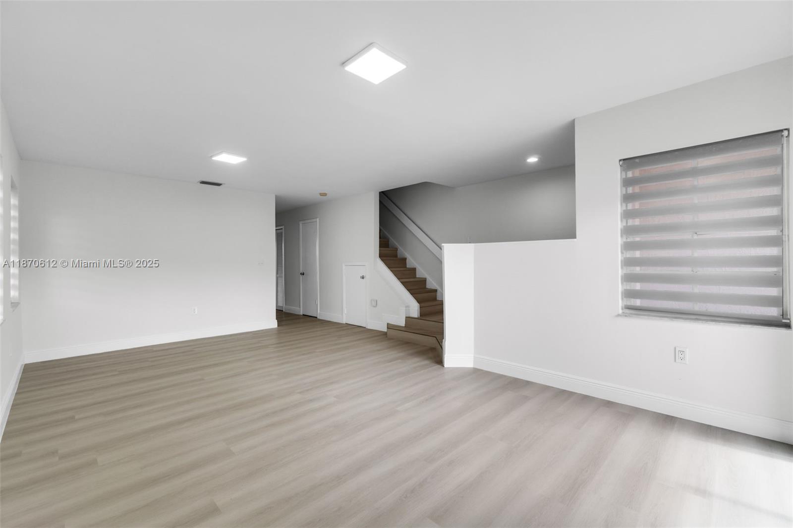 6514 Southwest 128th Place, Unit 6514 Miami, FL 33183 - Photo 6 of 46 an empty room with wooden floor and windows