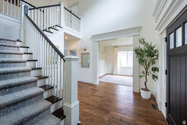 868 Braddock Lane Alpine, UT 84004 - Photo 27 of 64 Grand entryway featuring rich wood-finish flooring, a contemporary staircase with dark treads and white risers, and a prominent front door with multiple glass lites