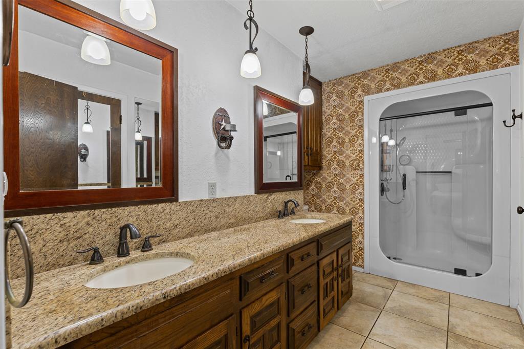 2900 Peel Road Springtown, TX 76082 - Photo 14 of 34 a bathroom with a granite countertop sink a mirror and shower