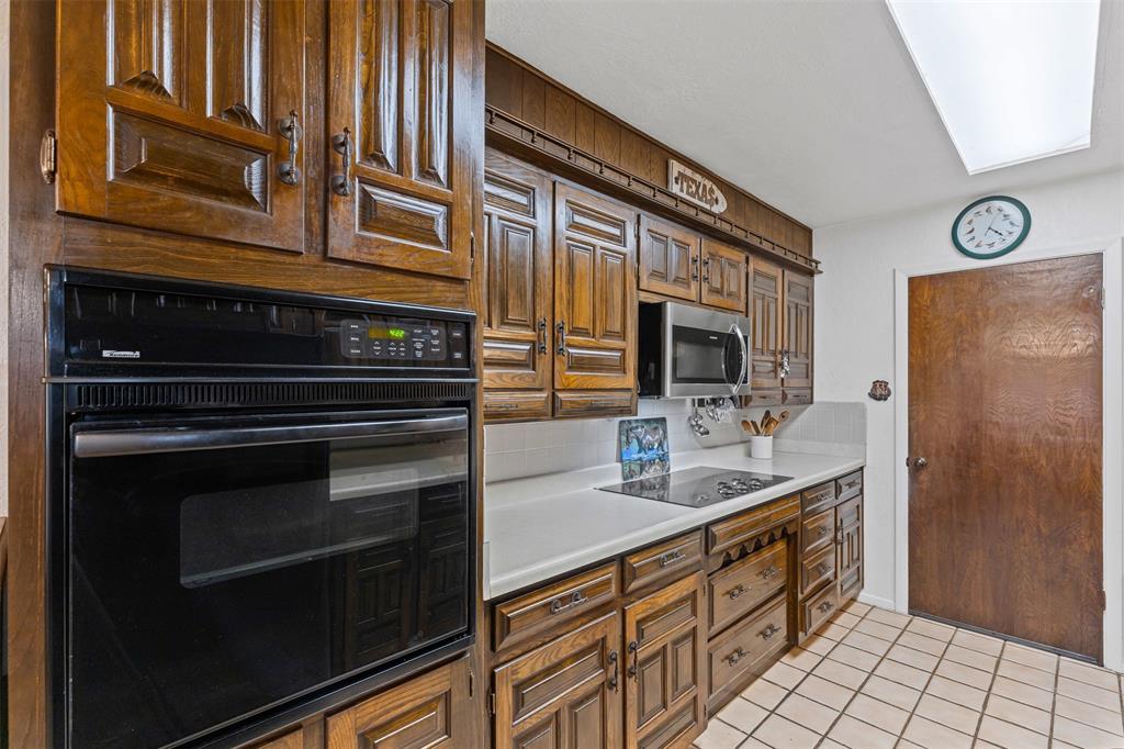 2900 Peel Road Springtown, TX 76082 - Photo 6 of 34 a kitchen with stainless steel appliances granite countertop a stove and a microwave