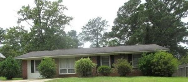 a view of a white house next to a yard