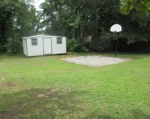 a backyard of a house with lots of green space and fountain